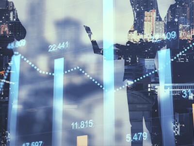 Superimposed in front of silhouettes of people in business attire, a graph shows numbers going up.