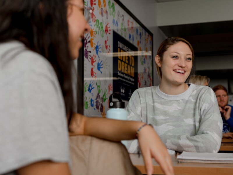 Two women talking in a classroom