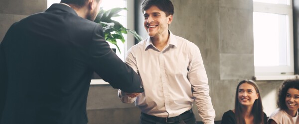 Young professional is congratulated on job promotion