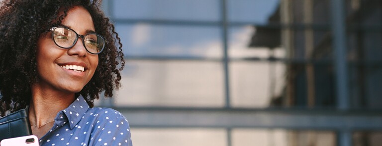 smiling african american woman in blue polka dot shirt holding a binder