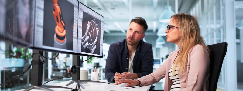Mechanical engineers reviewing a digital design together