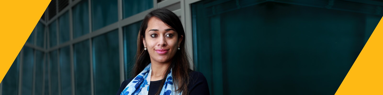 Woman wearing blue floral scarf smiles confidently