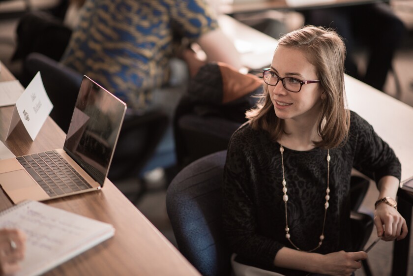 Marquette student wearing glasses sits in a lecture room