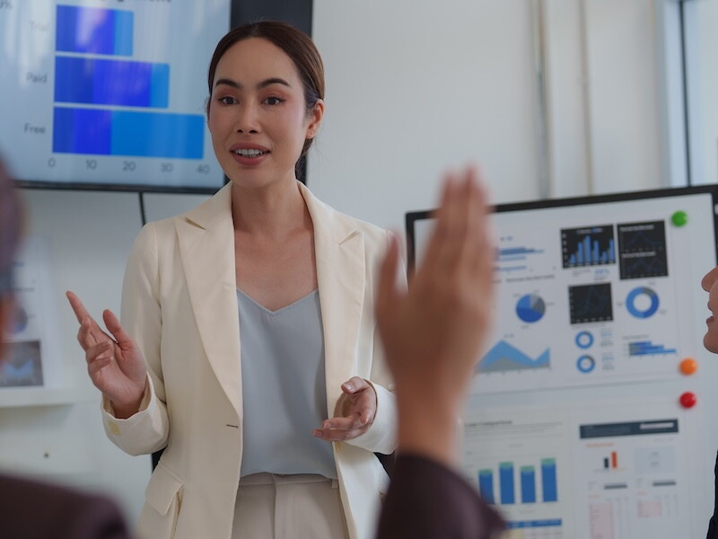 Business professional presenting data visualizations to colleagues during a team meeting.