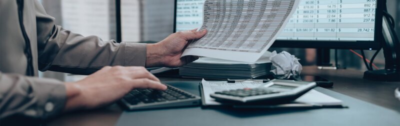 Investors reviewing financial statements for data cost, balance, profit and currency.