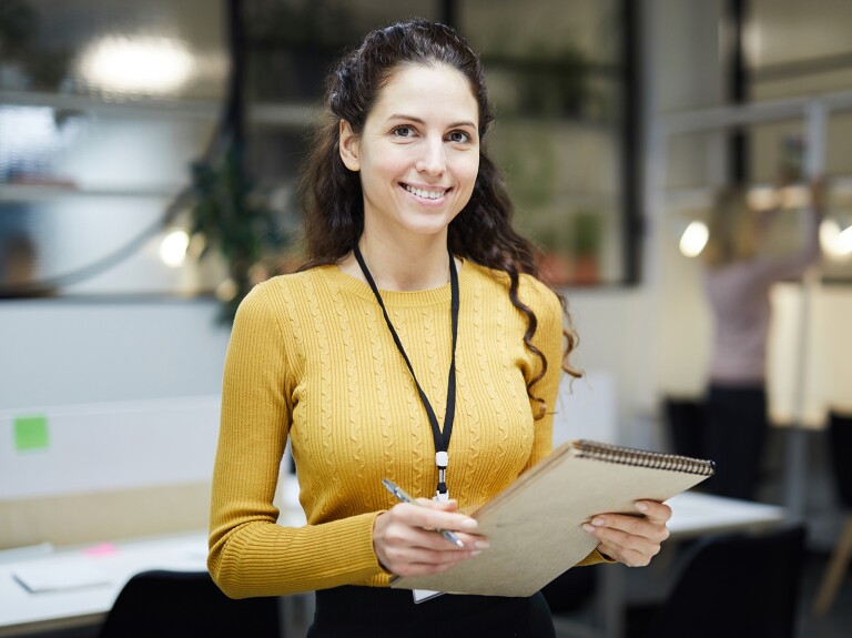 lady in yellow sweater with clipboard in hand