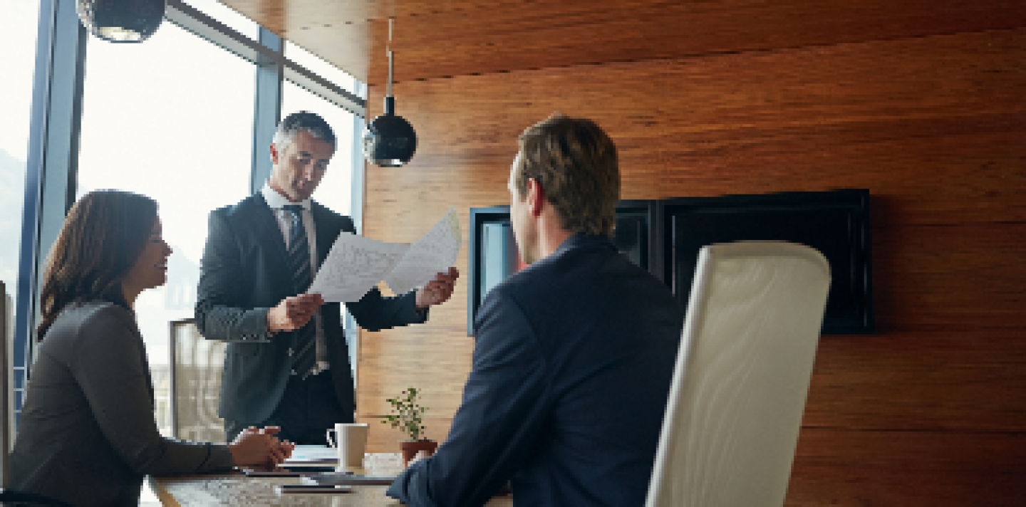 man looking over paperwork in an office meeting