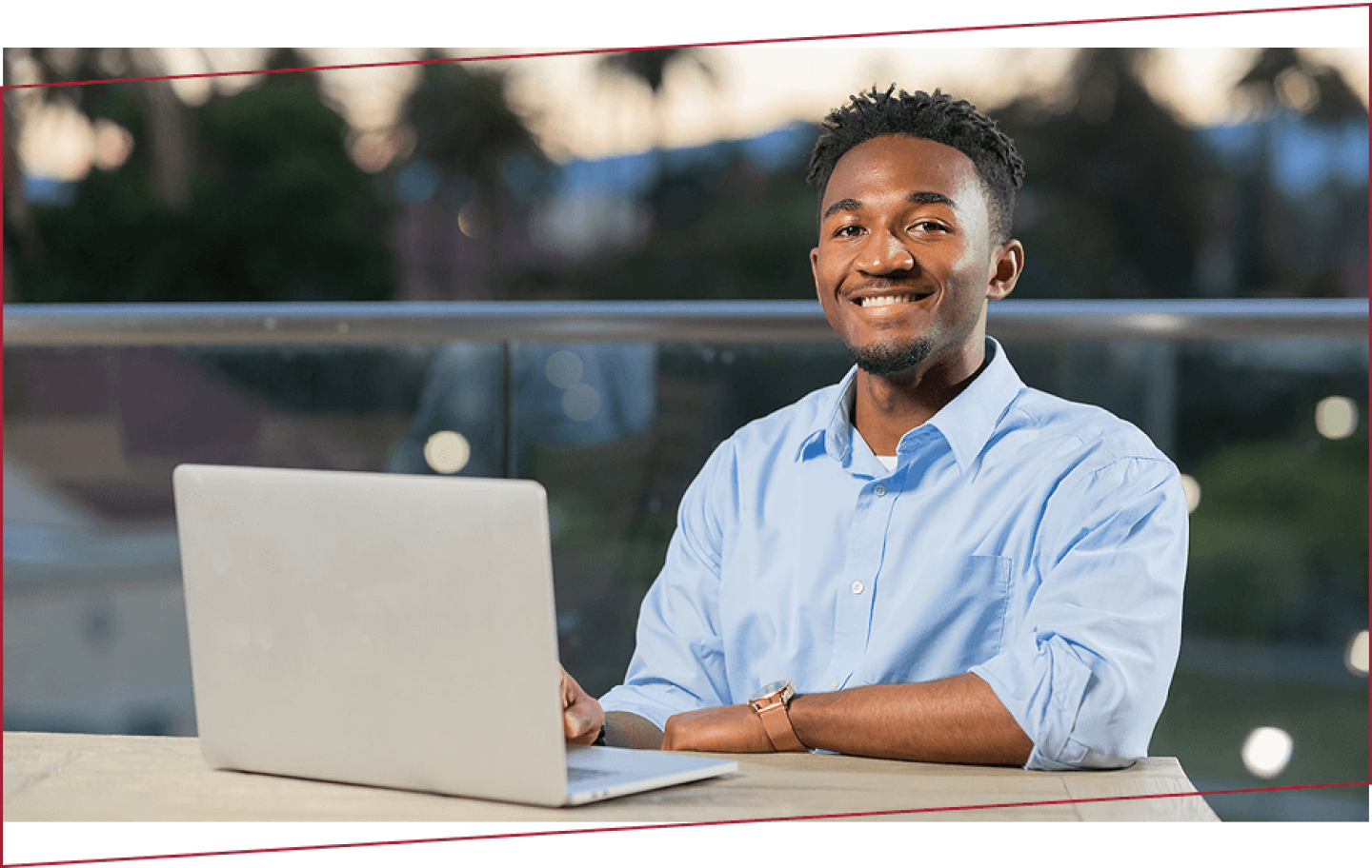Smiling man seated with laptop