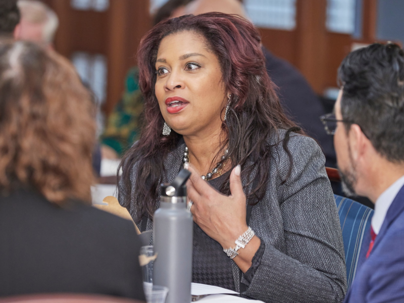 Professional woman at conference speaking to two people