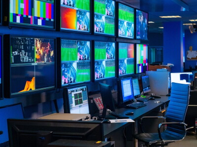 The control room for a sports game broadcast, full of screens and computers.