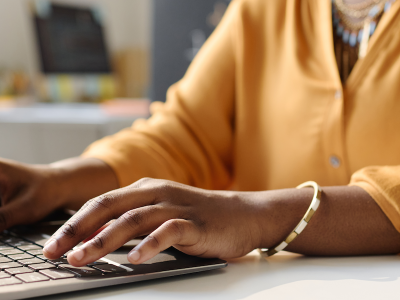 Close-up of Black woman teacher working on laptop at school