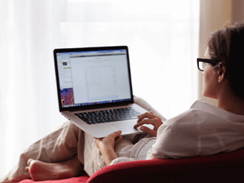 Woman reclined in chair using laptop