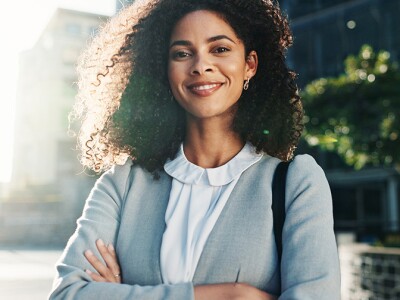 Confident social worker standing with arms crossed on a city street