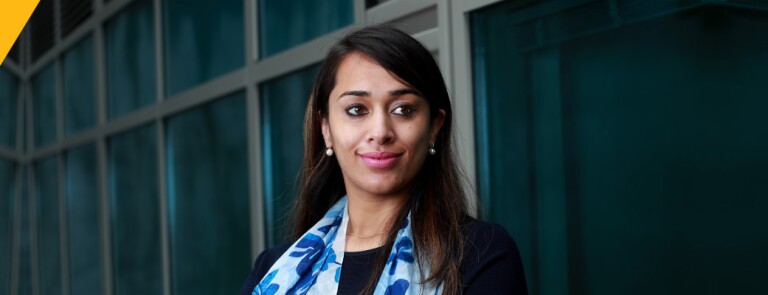 Woman wearing blue floral scarf smiles confidently