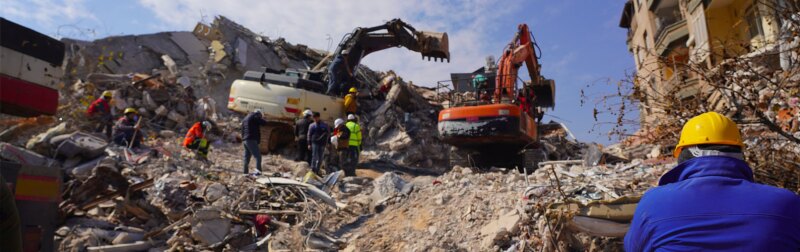 heavy excavator equipment being used to evacuate and search for earthquake victims