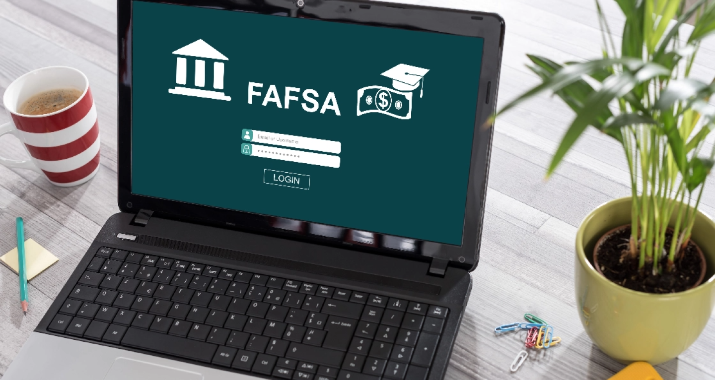 Laptop with screen showing FAFSA website login page