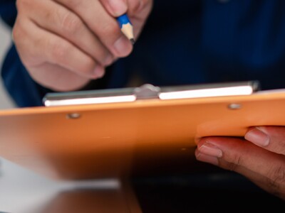Man holding clipboard at desk
