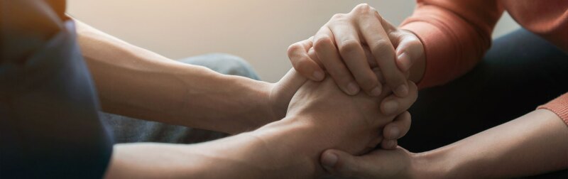 Counselor sitting and touch hand young asian man near window.