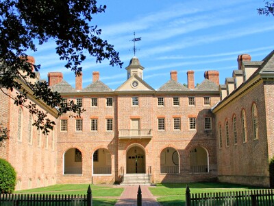 orange-brick-building-on-green-grass-with-blue-sky-and-tree-on-the-left