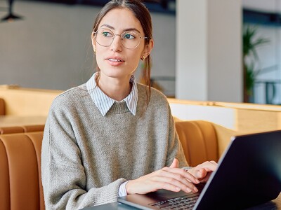 Online student working on her laptop in a cafe.