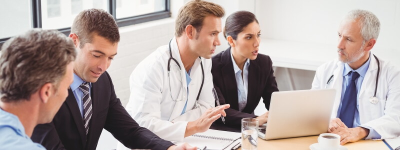 Healthcare administrators and physicians discuss organizational policies.