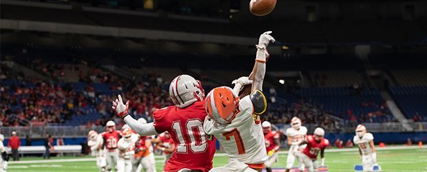red-white-jersey-football-players-jumping-for-ball-in-stadium