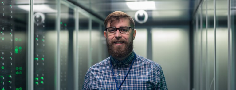Male professional stands in server room