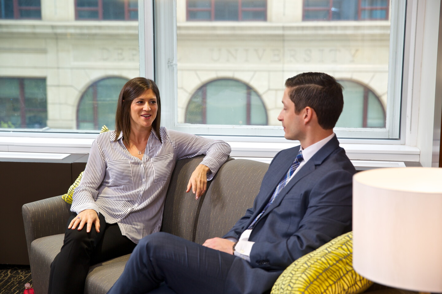 Two professionals conversing in a room at DePaul University