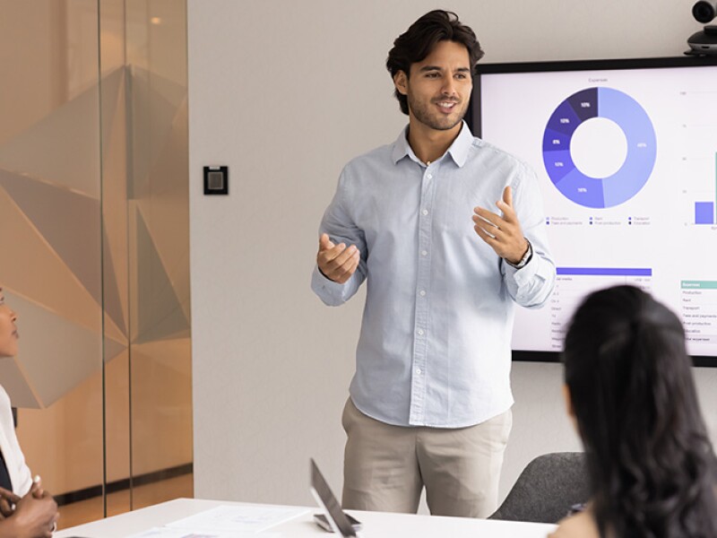Male analytics professional presenting data to teammates
