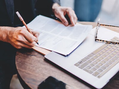 Man at a cafe reads about the Dean of YU Sy Syms, Dr. Noam Wasserman.