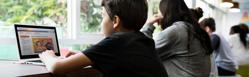 Group of young students using laptops in a classroom