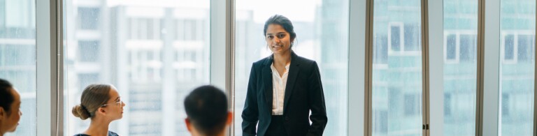Diverse team in downtown office holds meeting at table