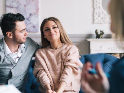 Young couple sitting on a blue couch in counseling session
