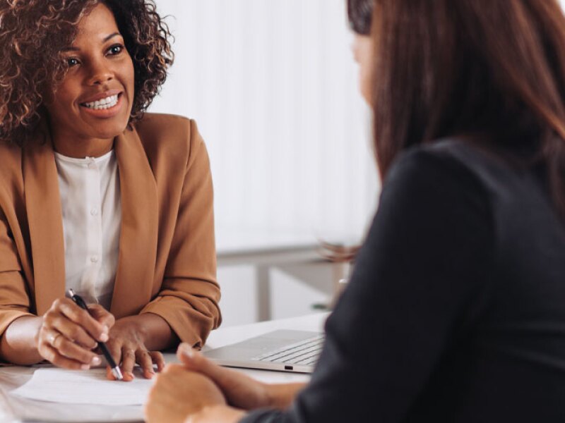 Woman consulting with a female financial manager at the bank.