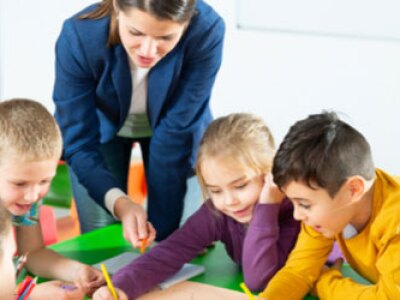 Teacher instructs a classroom of five children.