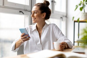 Creative business woman using smartphone in loft office.