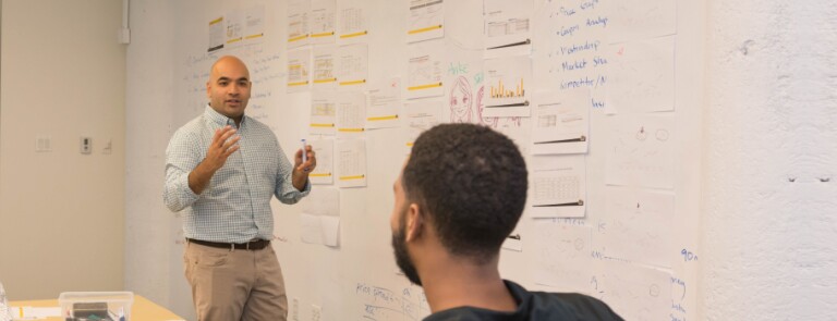 IMC students working through a product market strategy on a white board