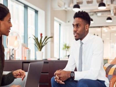 Two professionals holding an informal meeting in office lobby