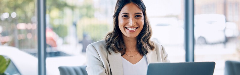 Smiling woman at a desk on a laptop
