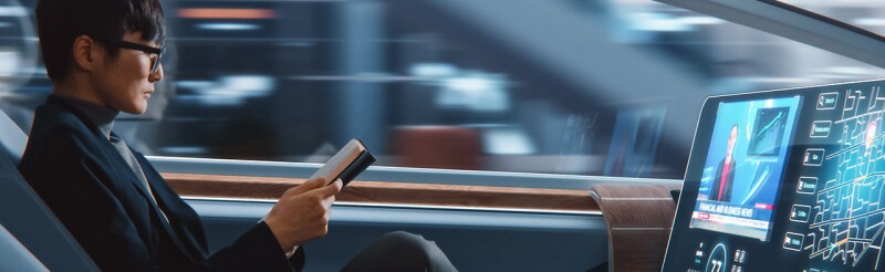 Businessman reading notebook and watching news while sitting in a autonomous self-driving car