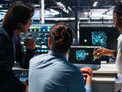 IT specialists working in data center, analyzing performance data using AI