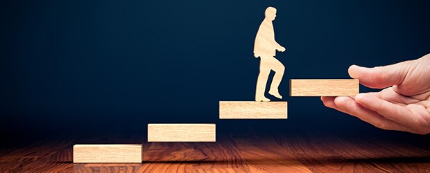 Woodblock illustration of a man walking up stairs while evaluating the career benefits of an online MBA versus an MEM degree.