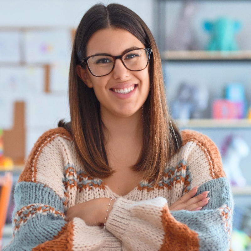 young woman smiling wearing glasses and a sweater