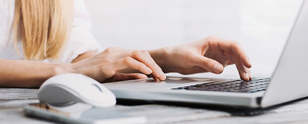 Female hands typing on computer keyboard searching for social work buzzwords