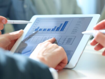 Three-Hands-Pointing-At-Graph-Displayed-On-Tablet