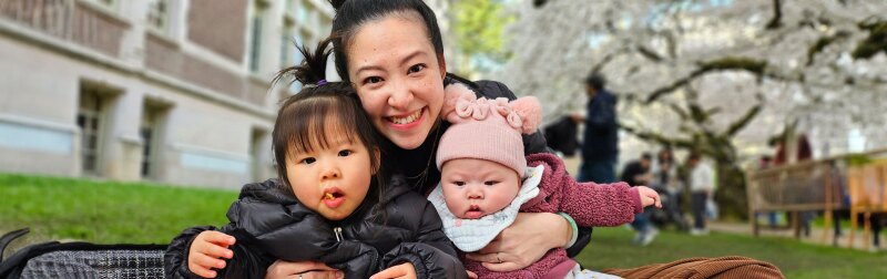 Pariya Rojitanongchai sitting with her two children in a university courtyard.