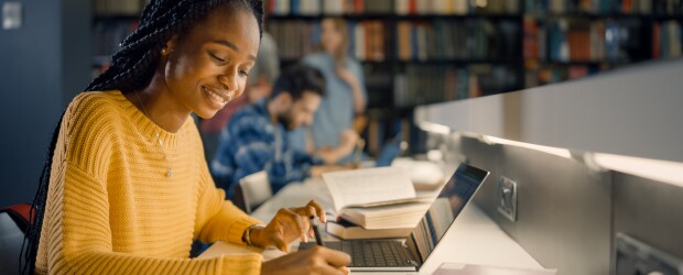 Woman focused on her laptop in a library