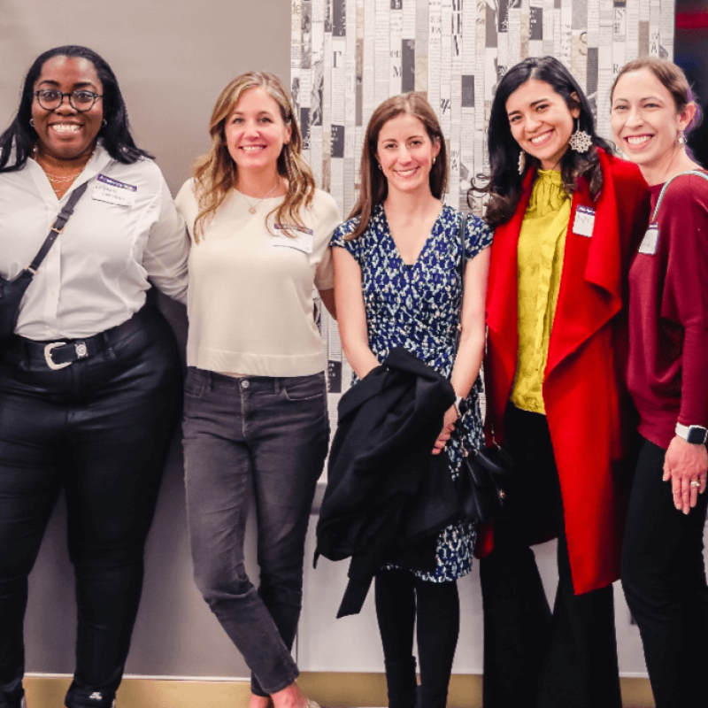Five smiling women with nametags at networking event