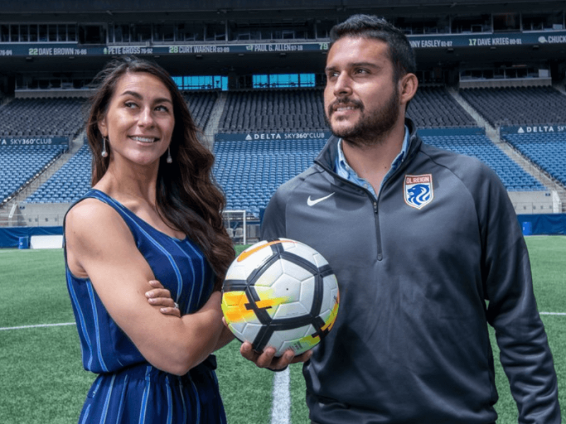 Man and woman with soccer ball on soccer field
