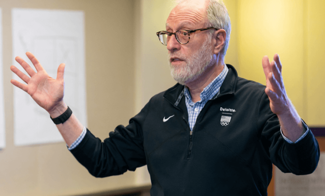 Man gesturing with both arms while speaking
